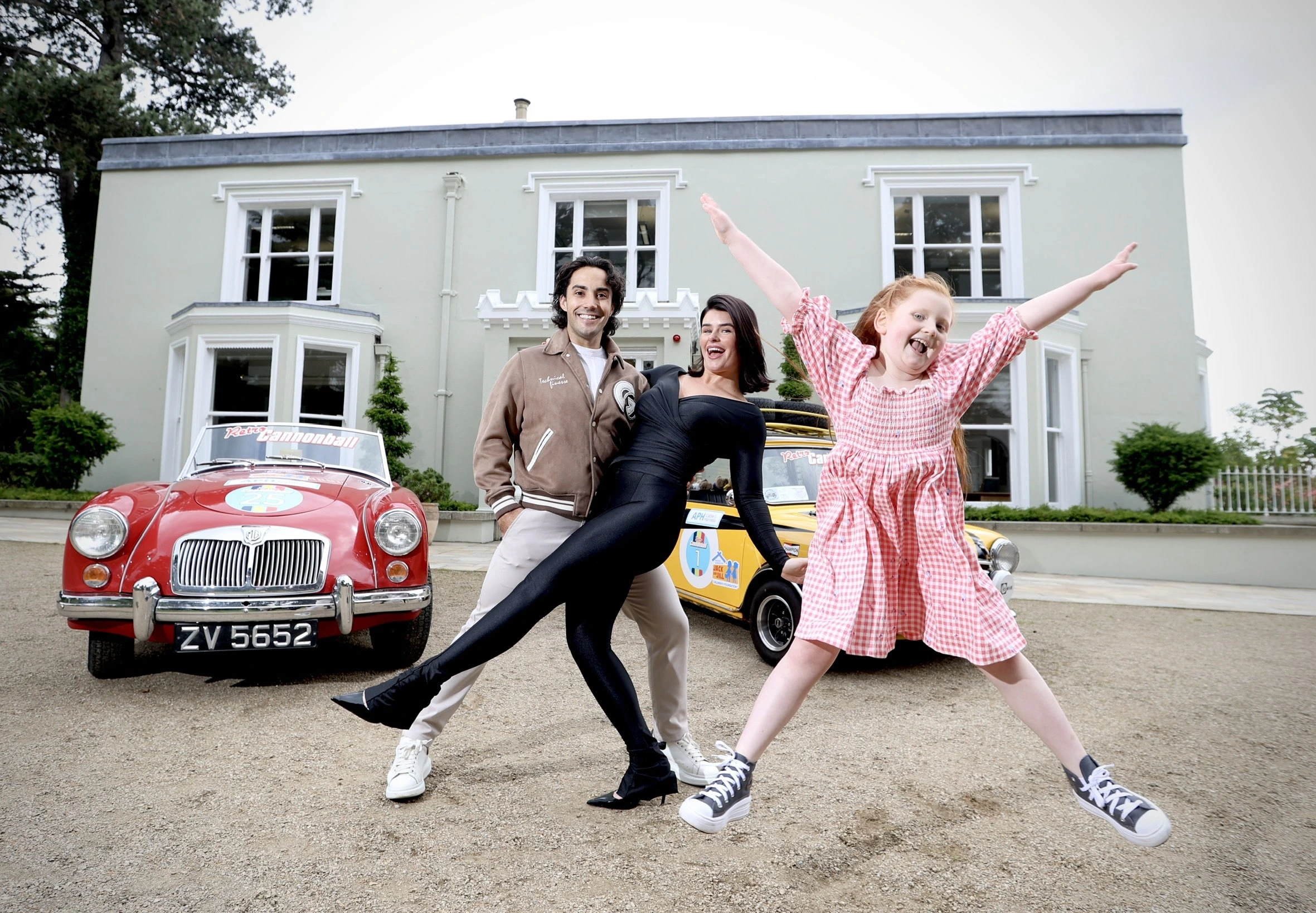 Jack Carter, Karen Byrne and Jack and Jill child sibling posing in front of Retro cars