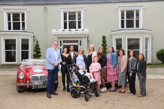 Jack and Jill family, staff, nurse and Jake Carter and Karen Byrne standing in front of retro cars