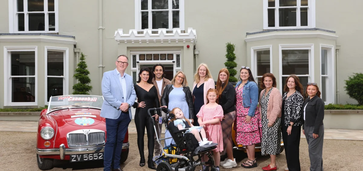Jack and Jill family, staff, nurse and Jake Carter and Karen Byrne standing in front of retro cars