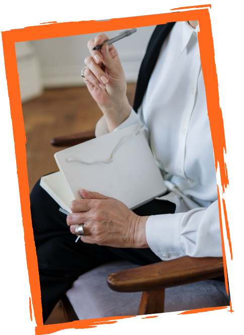 Image of an elderly lady holding an envelope and pen