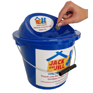 Hand dropping a coin into a blue Jack and Jill Children's Foundation fundraising bucket.
