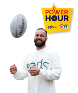 Rugby player Jamison Gibson-Park smiling while wearing an orange Jack and Jill Children's Foundation t-shirt, alongside the Power Hour campaign logo.