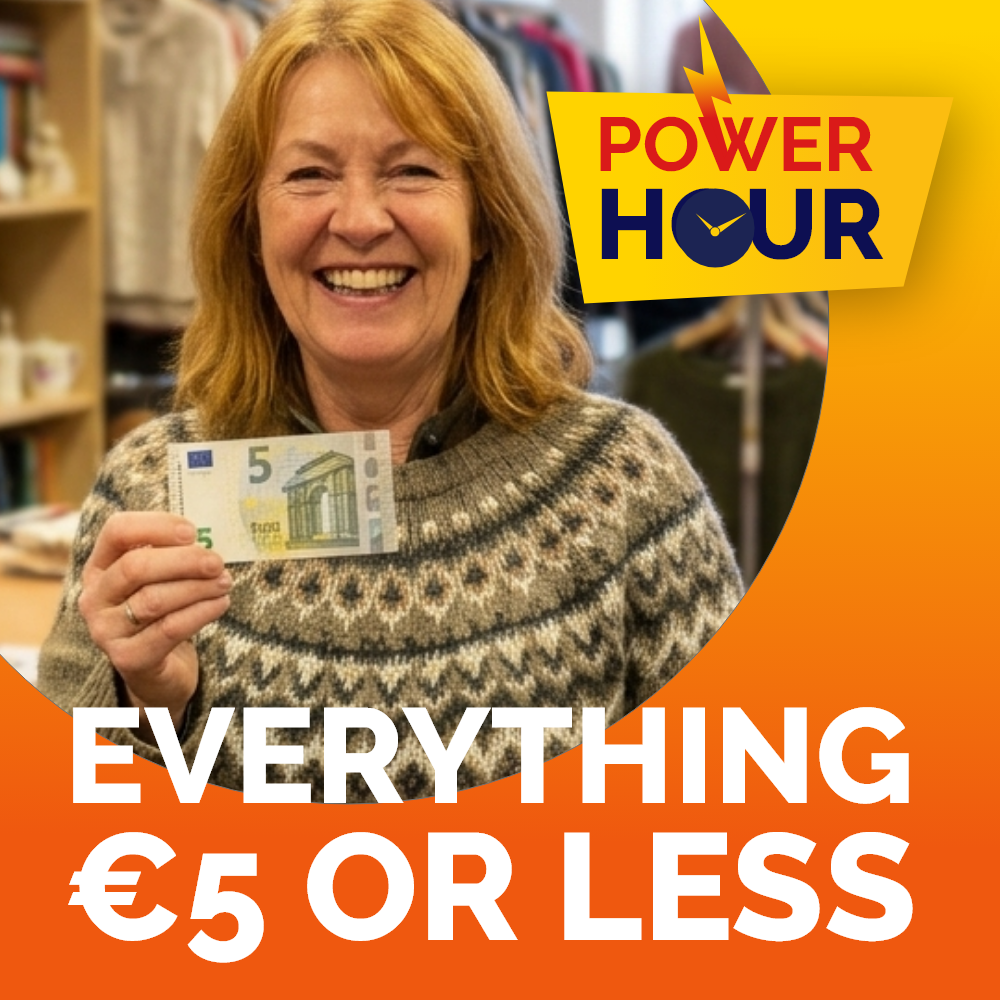 Power Hour Arklow A smiling woman wearing a patterned sweater holds up a 5 euro note inside a store, set on an orange graphic reading Power Hour: Everything €5 or Less.