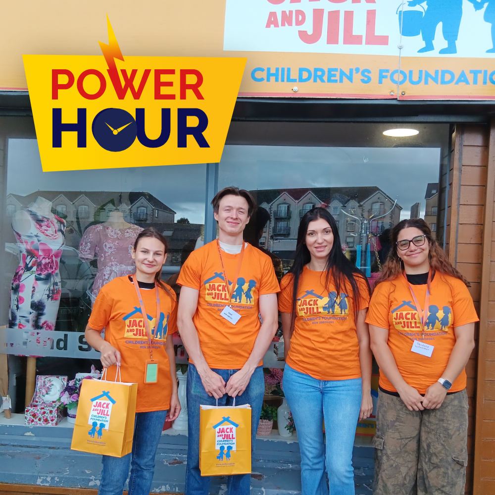 Power Hour Tralee Four Jack and Jill staff members wearing orange t-shirts and holding yellow gift bags outside the store, featuring the Power Hour logo.