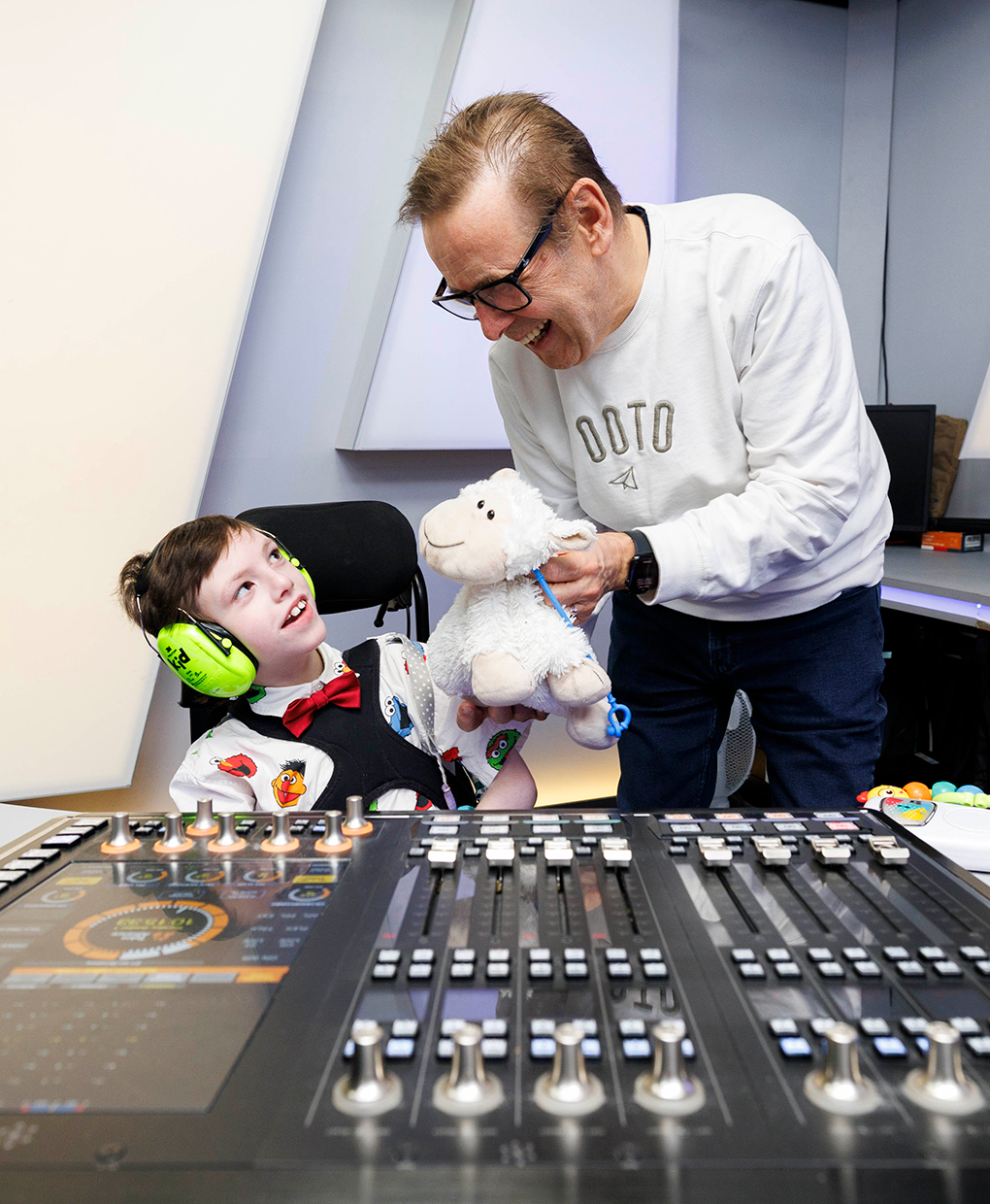 Ian Dempsey and James Garrahan Ian Dempsey sharing a laugh with James in a studio, presenting him with a stuffed toy.